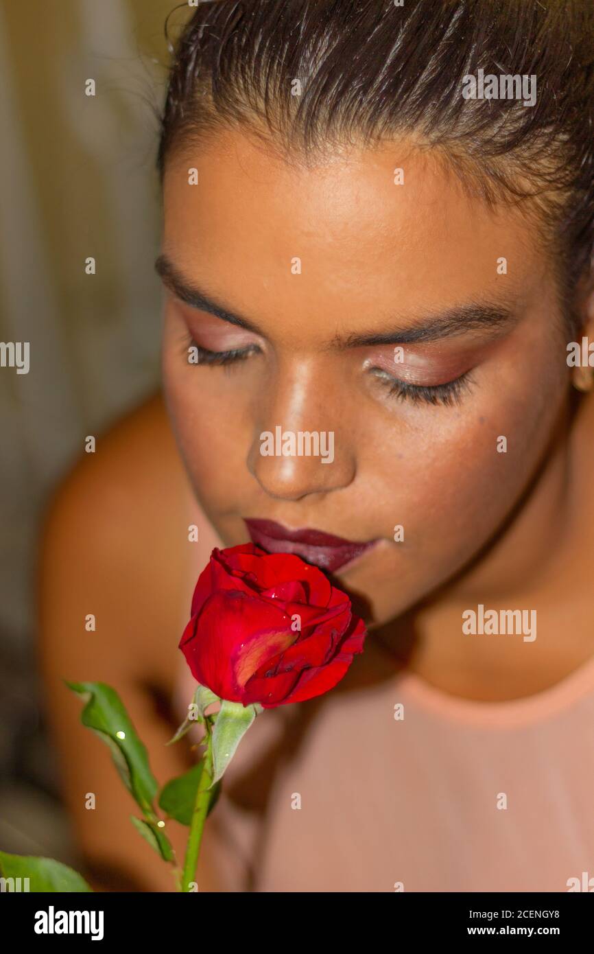A girl smelling a red rose Stock Photo