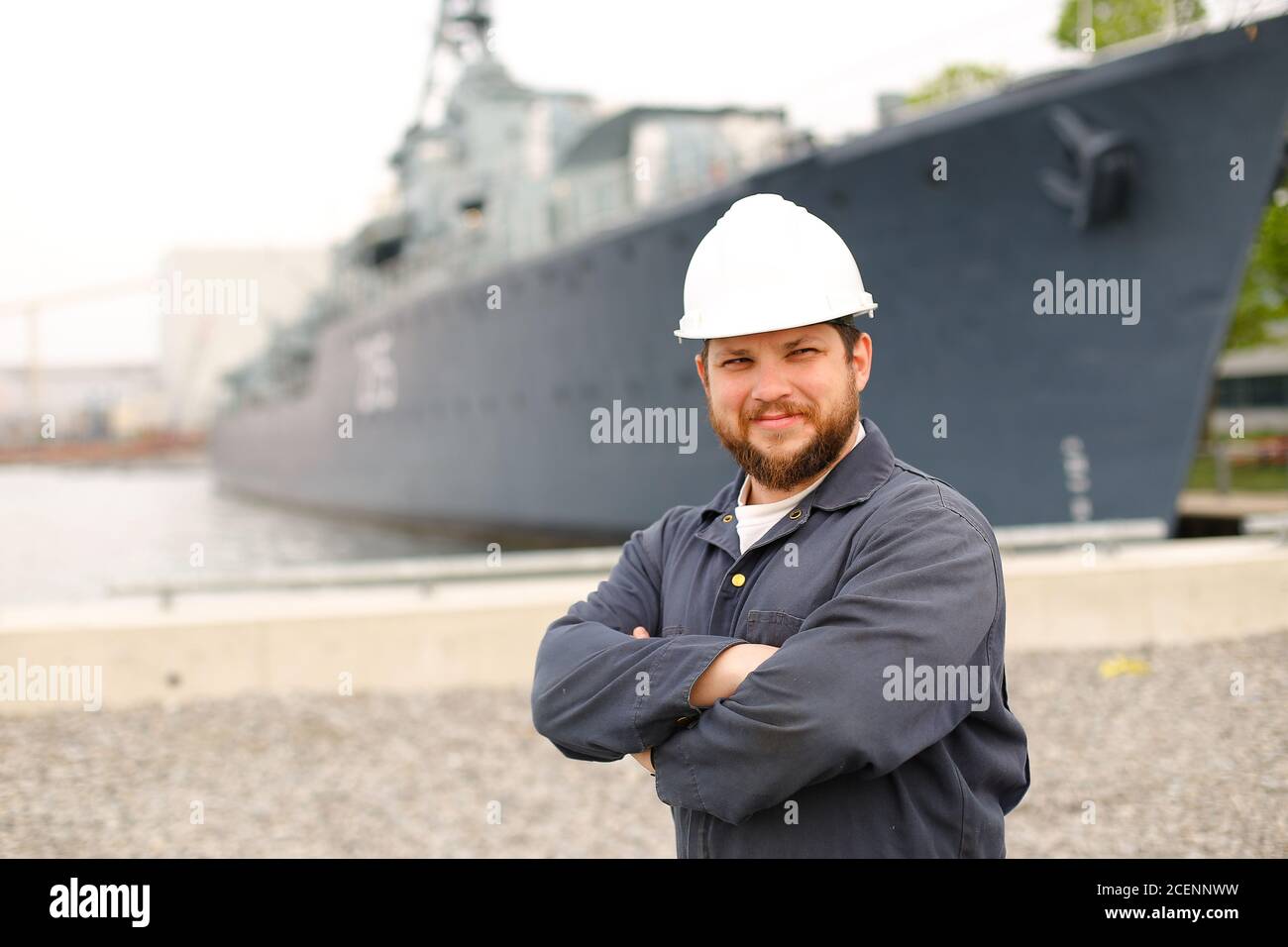 Portrait of marine first mate standing near big vessel in background. Stock Photo