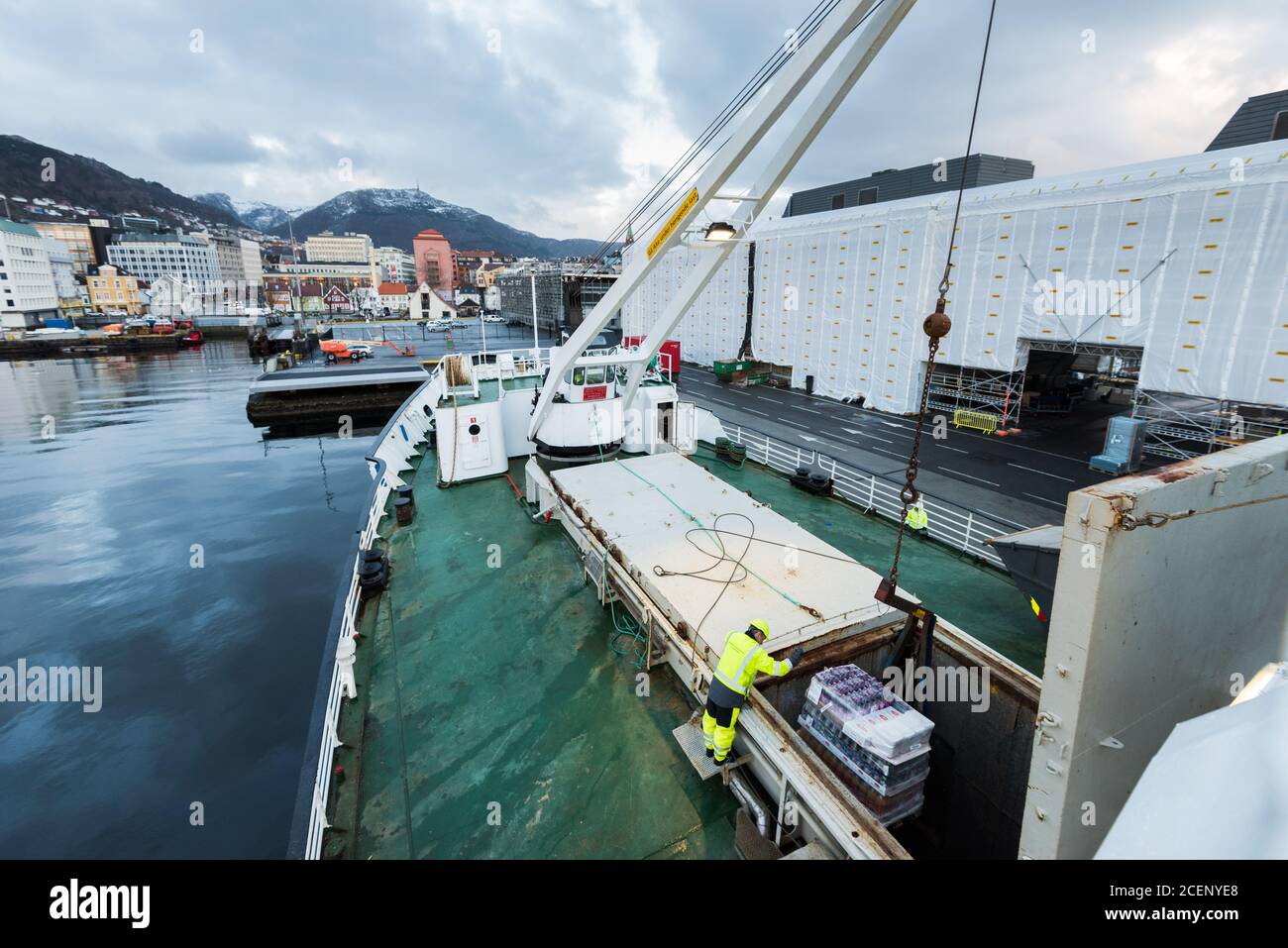 Unloading cargo with a crane on the mailboat MS Lofoten of norwegian coastal line Hurtigruten lying in port in Bergen Stock Photo