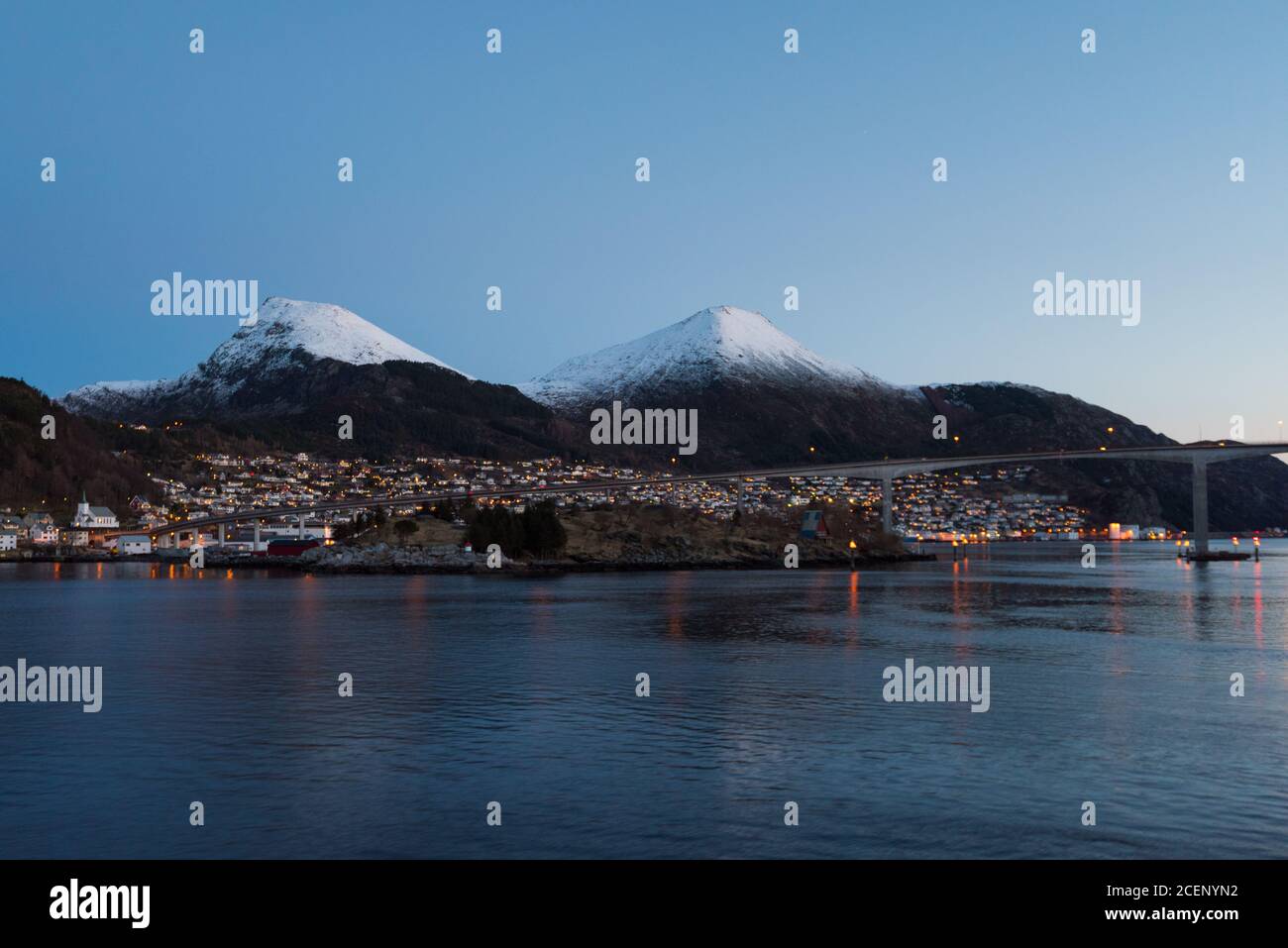 The town Maloy in Norway seen from cruise ship in early morning with snow capped mountains on clear winter day Stock Photo