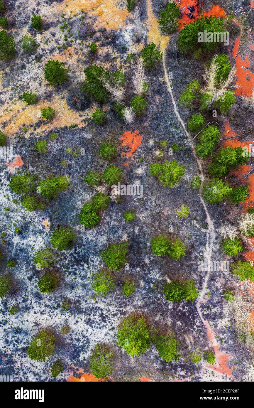 Gant, Hungary - Aerial horizontal drone view of abandoned bauxite mine with grteen trees at sunset. Red bauxite texture Stock Photo