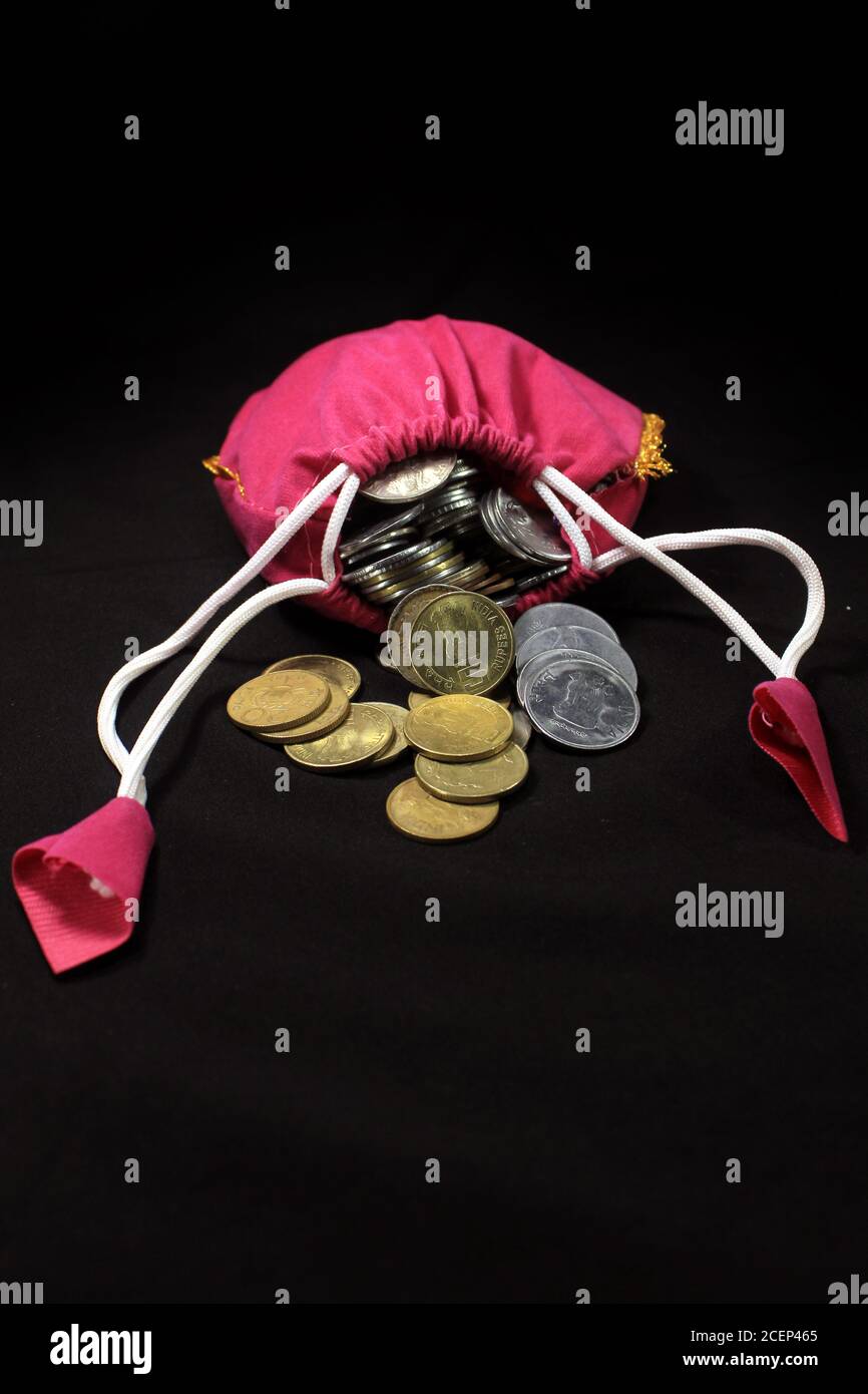 Pink Sack with Indian currency coins. Coin in cotton sack with money. Stacking coin in sack on black background, Money stack for business planning Stock Photo