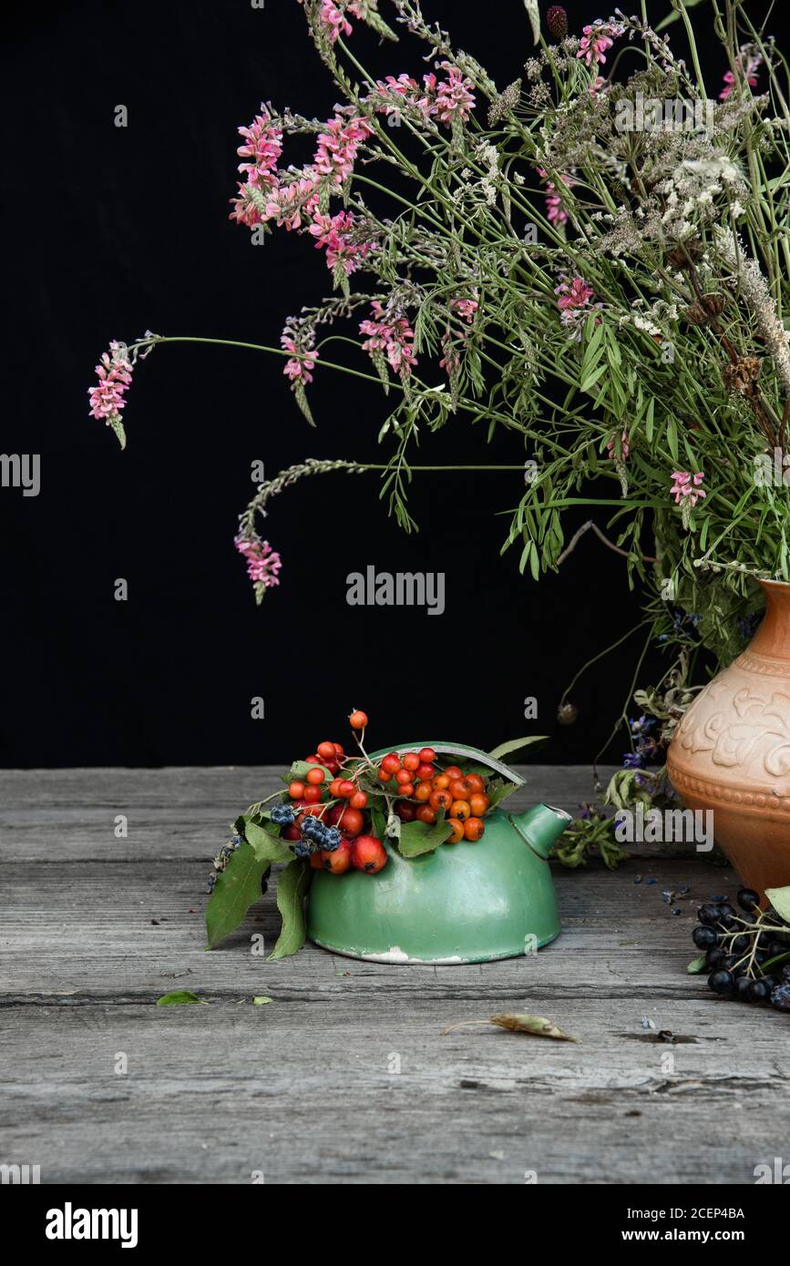 Still life with bouquets of wild berries and field flowers. Stock Photo