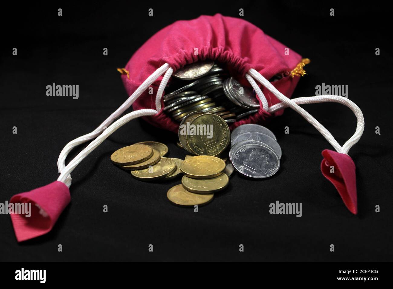 Pink Sack with Indian currency coins. Coin in cotton sack with money. Stacking coin in sack on black background, Money stack for business planning Stock Photo
