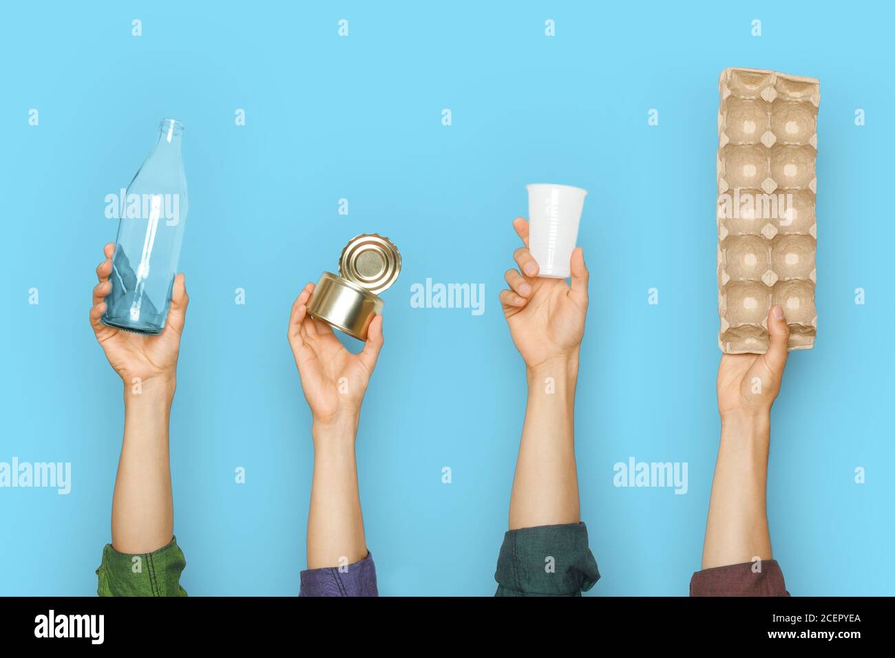 Different types of waste in the hands on a blue background. Stock Photo