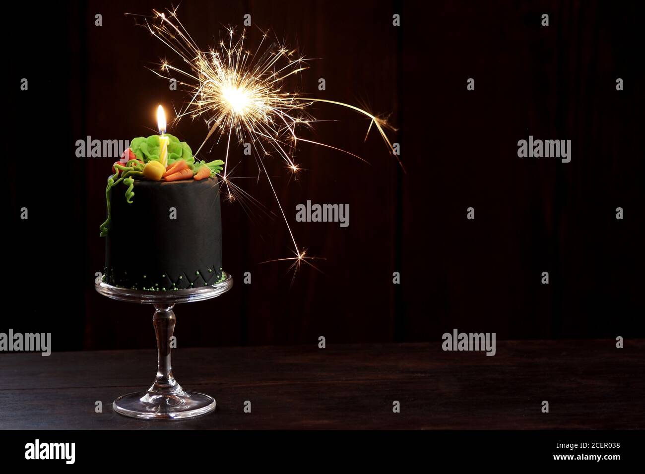 Birthday cake with candle, sparkler and gum paste vegetables Stock Photo