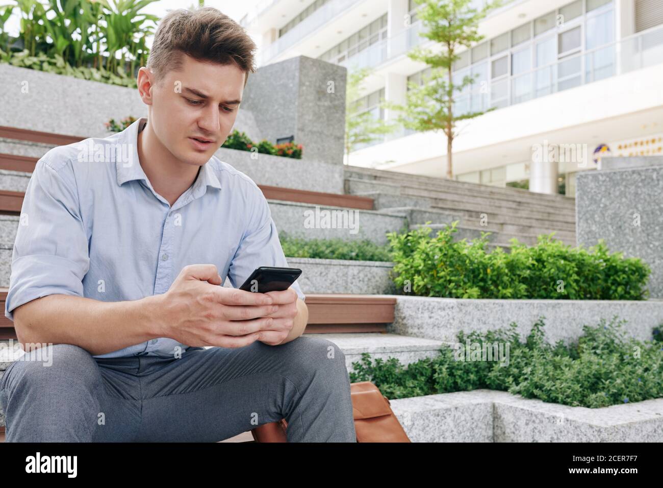 Texting frowning businessman Stock Photo