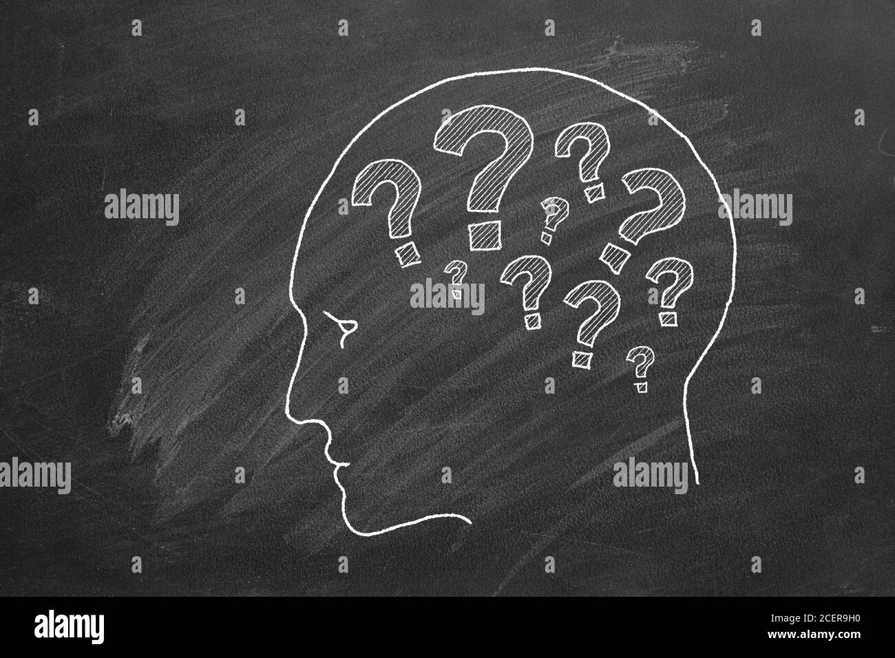 Human head with question marks inside. Animated Illustration on blackboard. Stock Photo