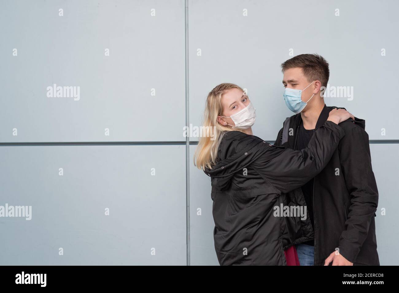 Young, happy, loving couple wearing masks and hugging Stock Photo - Alamy