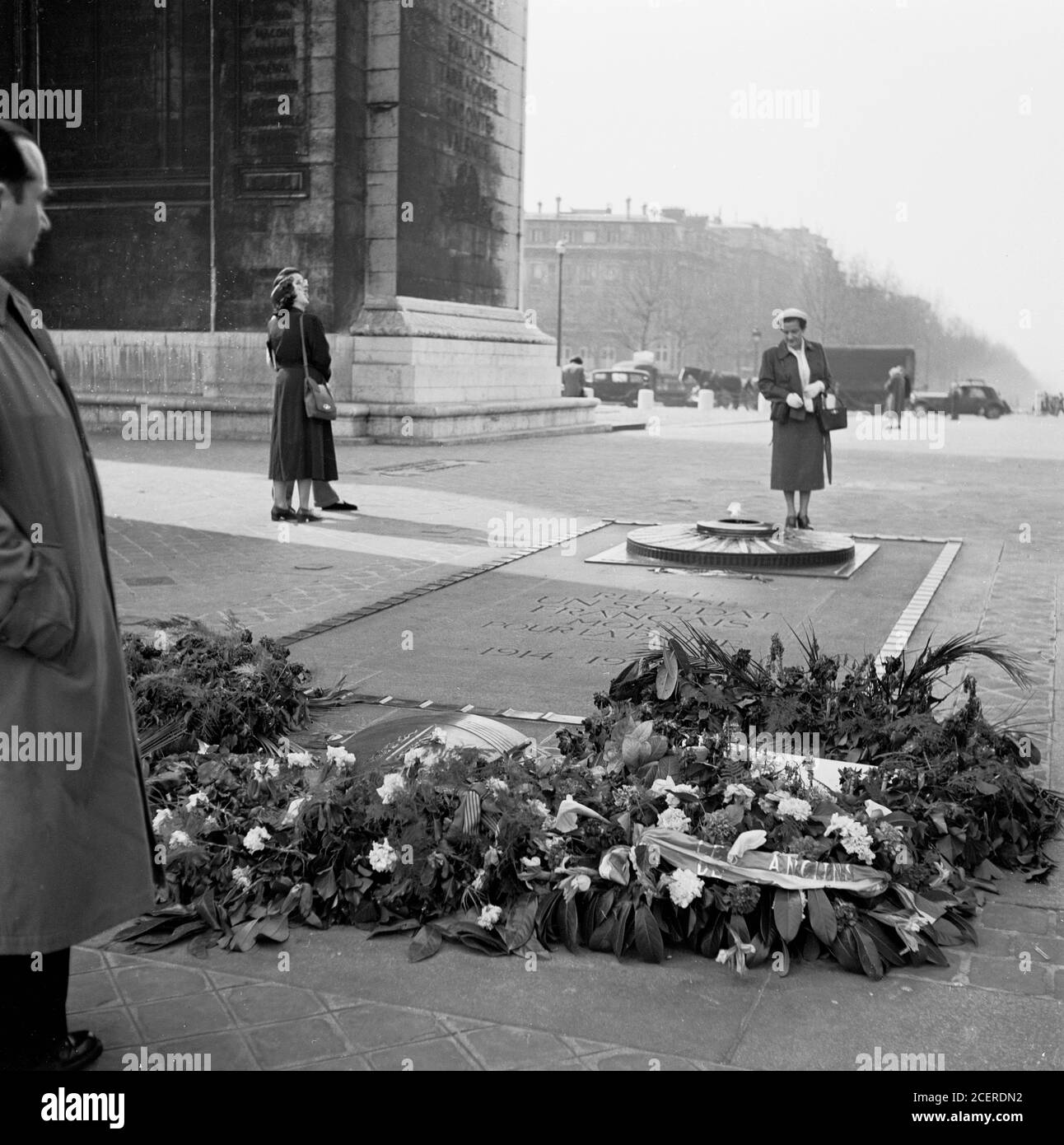 1950s, historical, Paris, France, a lady underneath the Arc de Triomphe, reading the memorial enscribed, 'Ici Repose Un Soldat Francais Mort Pour La Patrie 1914-1945', the Tomb of the unknown Soldier from WW1, with its eternal flame. The memorial was stablished on Armstice Day 1920. Stock Photo