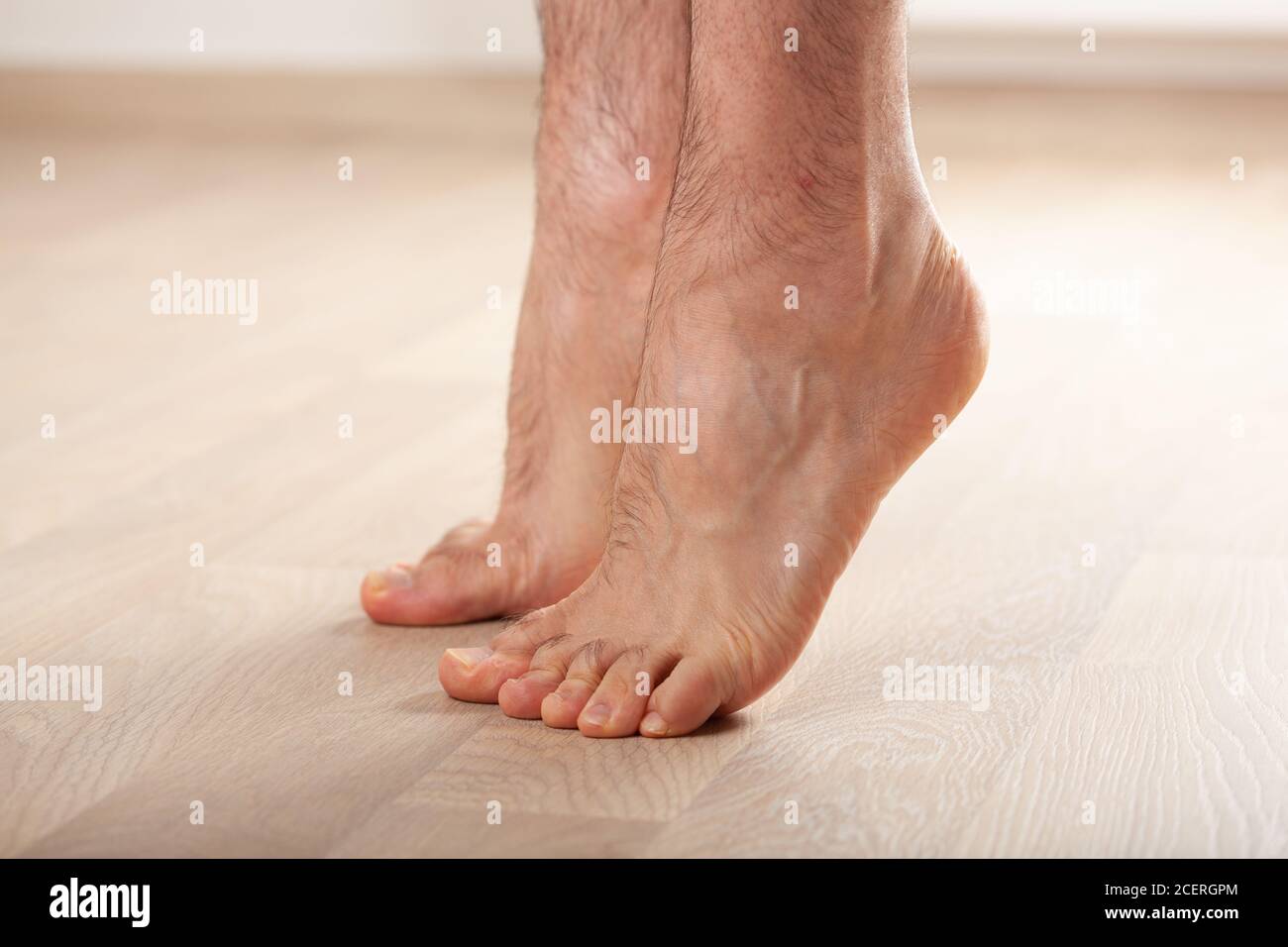 man doing flatfoot correction gymnastic exercise standing on toes at home Stock Photo Alamy
