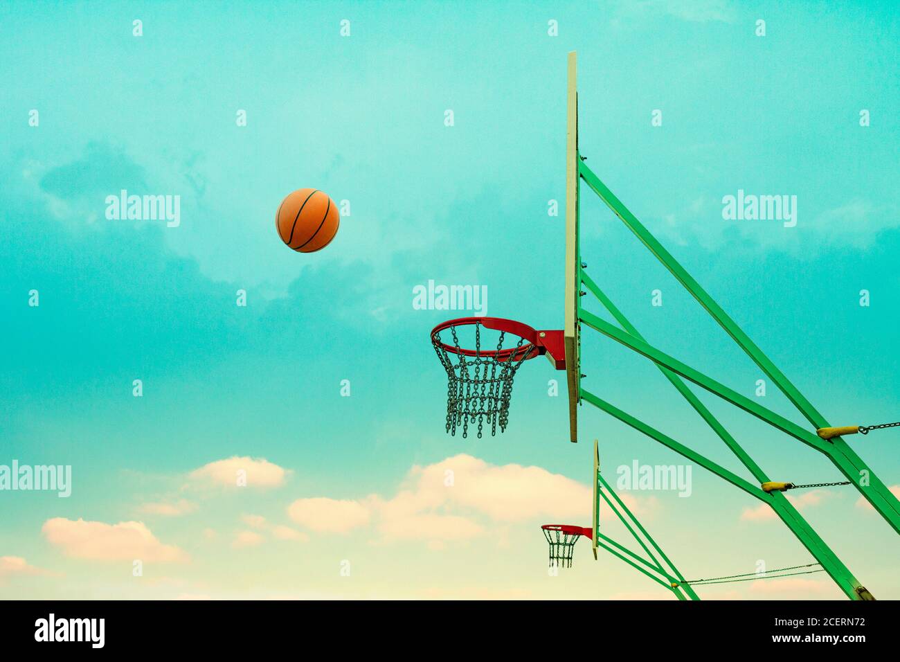 Thrown basketball flies to the chain basket. Stock Photo