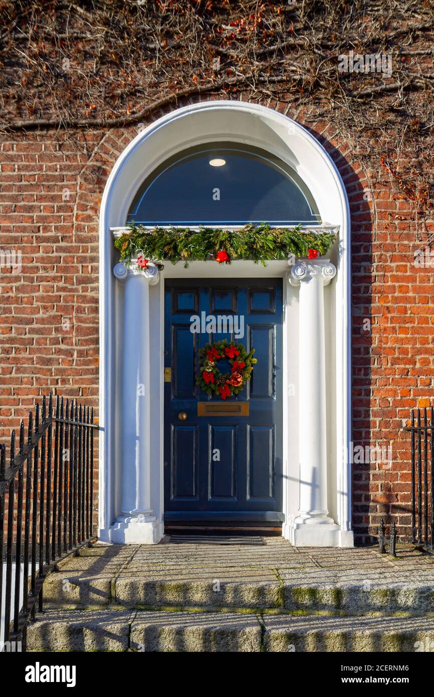 front door, decorated for Christmas with festive green garland
