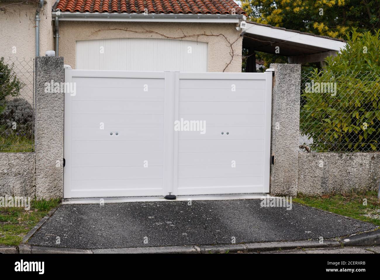 metal gate white fence on home suburb street access house garden Stock Photo