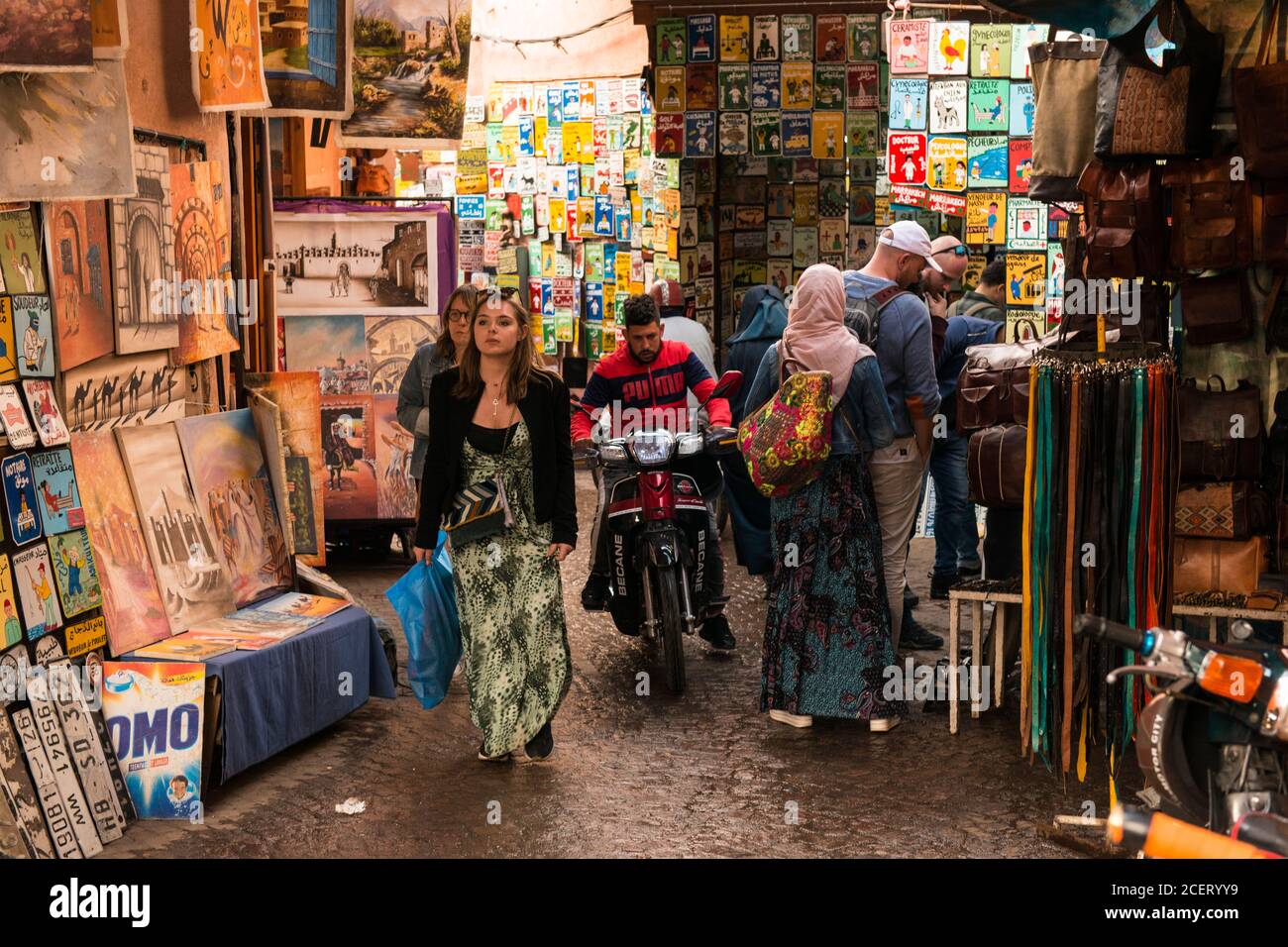 Tourists, shoppers and a man on a motorbike meet in the souk within the Medina, Marrakesh Stock Photo