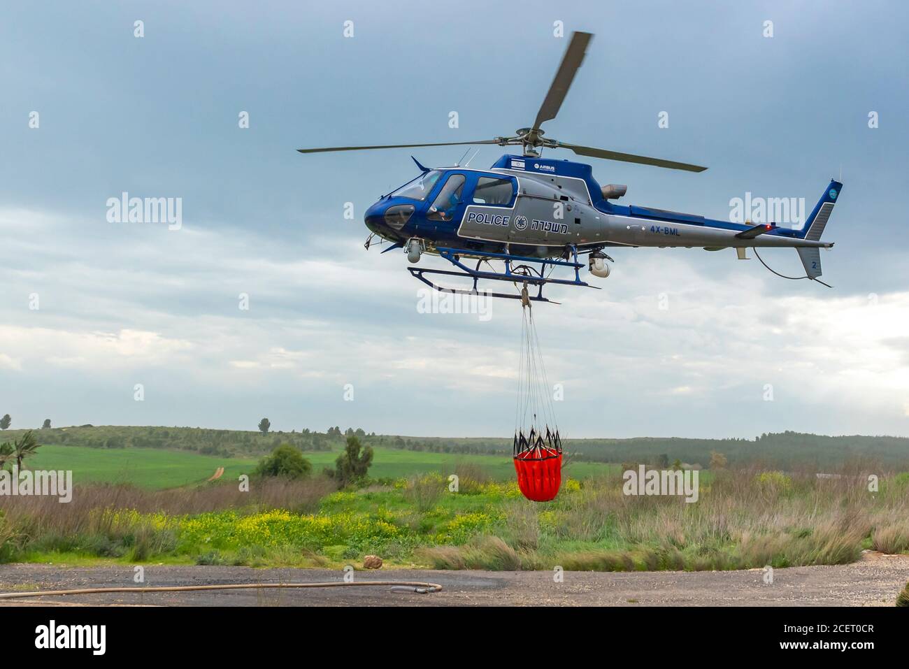 A police helicopter is used during a fire drill to airlift water to the fire zone Stock Photo