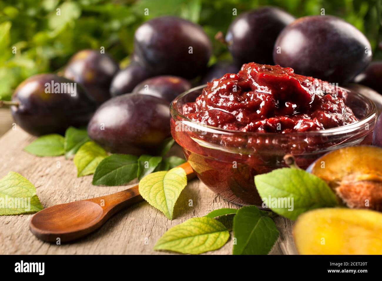 Jam of healthy organically grown plums with plum fruits on a wooden table background Stock Photo