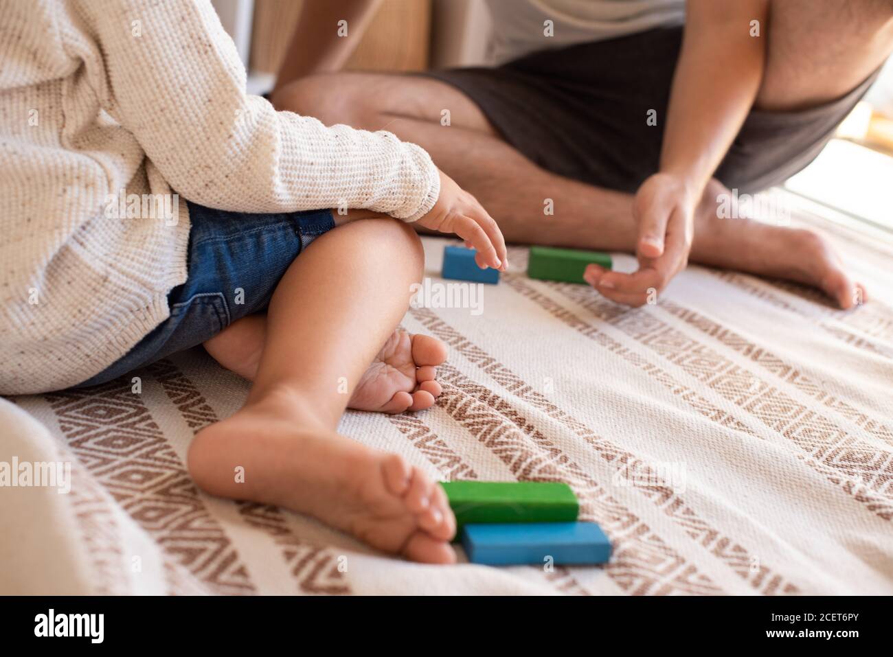 Little kid and his father playing at home with wood building blocks. Homeschooling. Stay at home. Family time Stock Photo