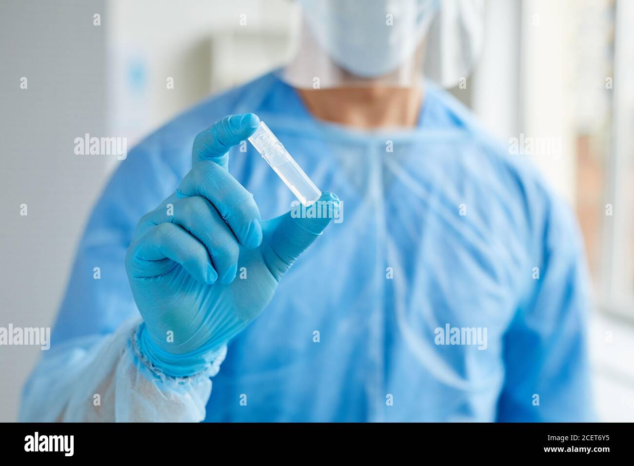 https://c8.alamy.com/comp/2CET6Y5/horizontal-medium-close-up-shot-of-unrecognizable-medical-worker-wearing-protective-uniform-holding-ampoule-with-transparent-liquid-2CET6Y5.jpg