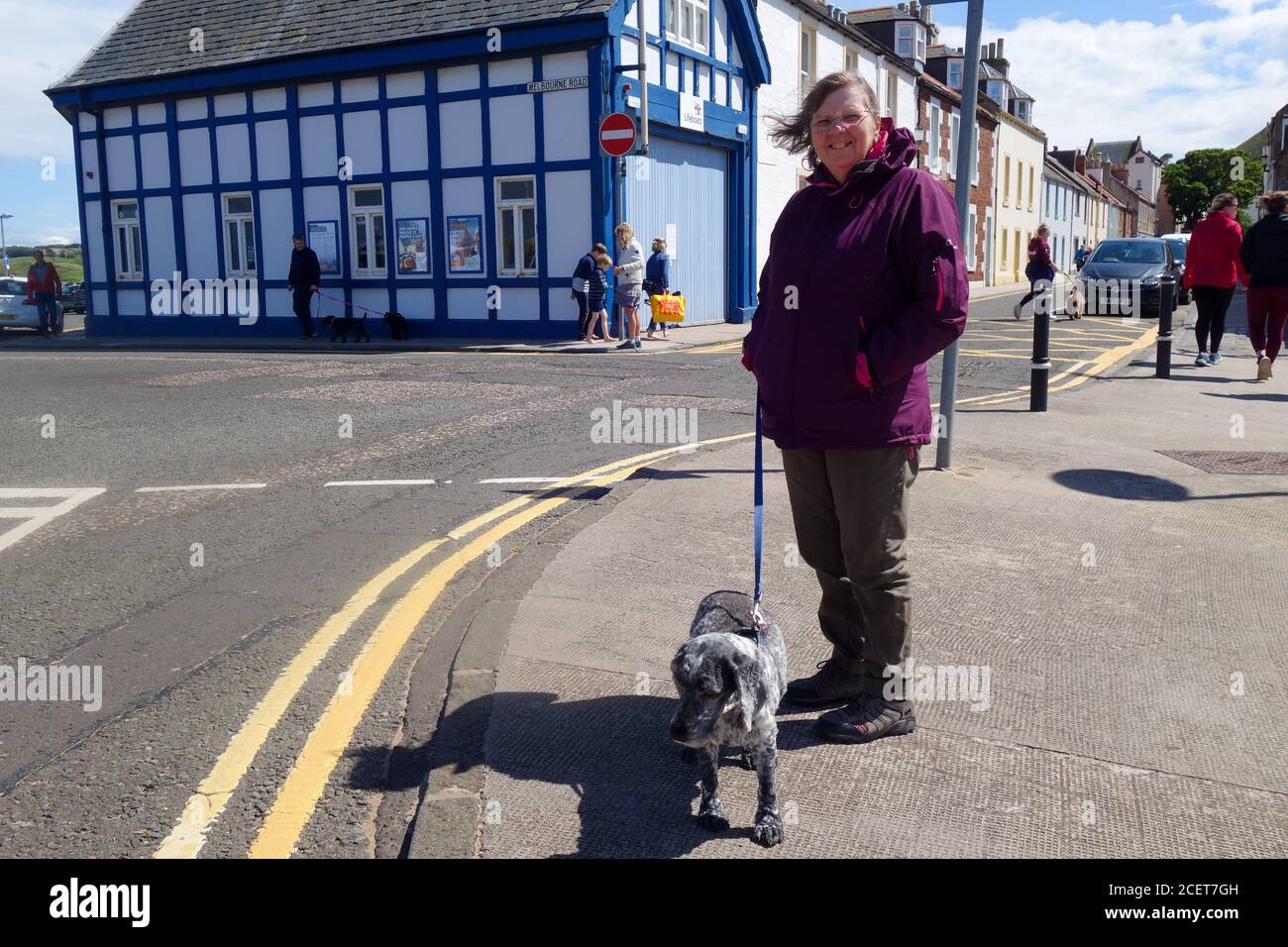 Woman with dog outside Lifeboat Station at North Berwick Stock Photo