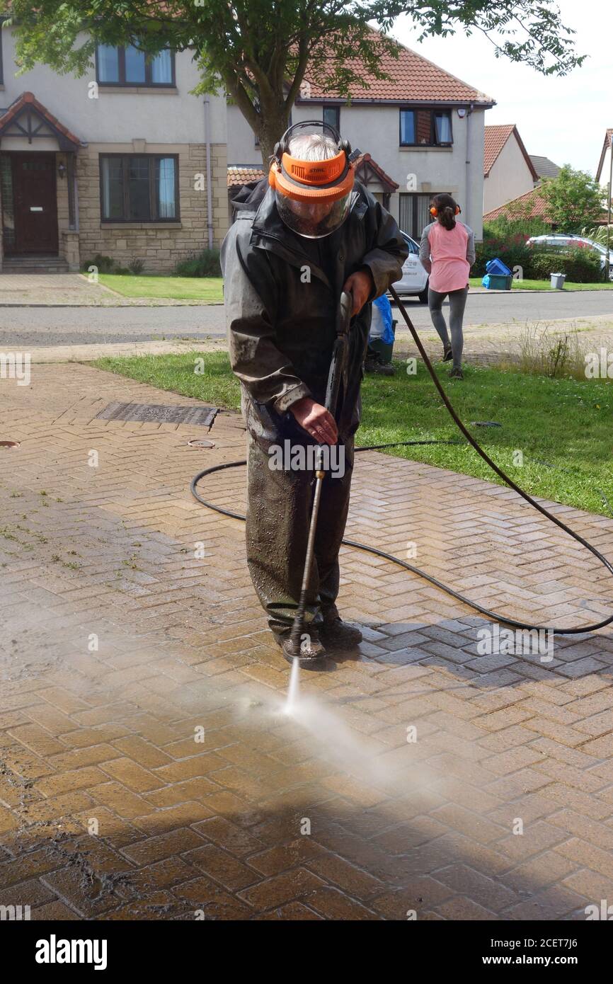 Man washing driveway using a pressure washer Stock Photo