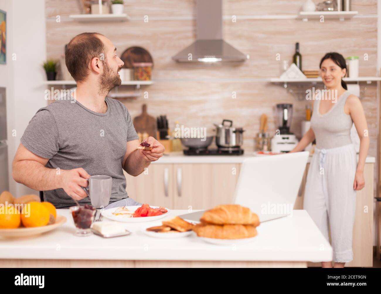 Excited freelancer working from home on laptop after reading a good news. Successful overjoyed euphoric entrepreneur at home in the morning, winner and business triumph Stock Photo
