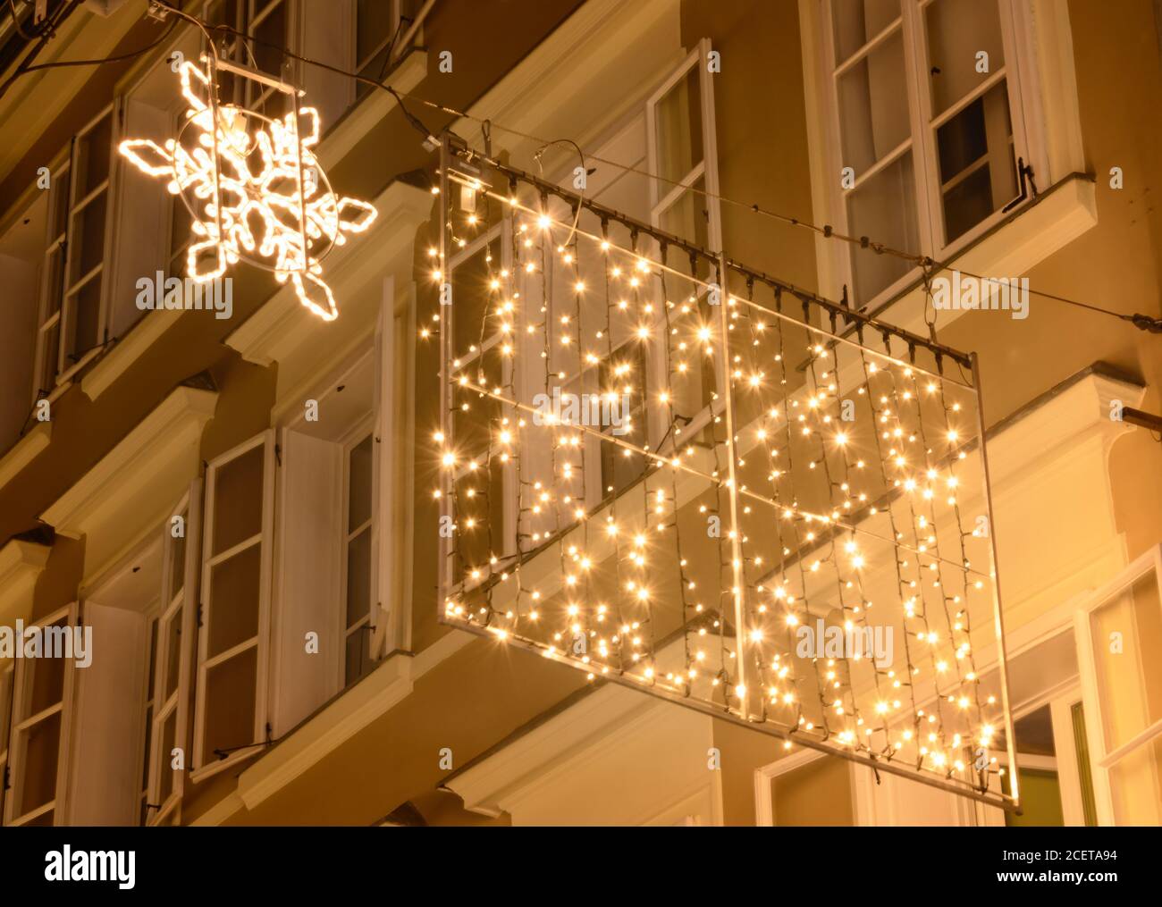 Snowflake and garland against the background of evening windows Stock Photo