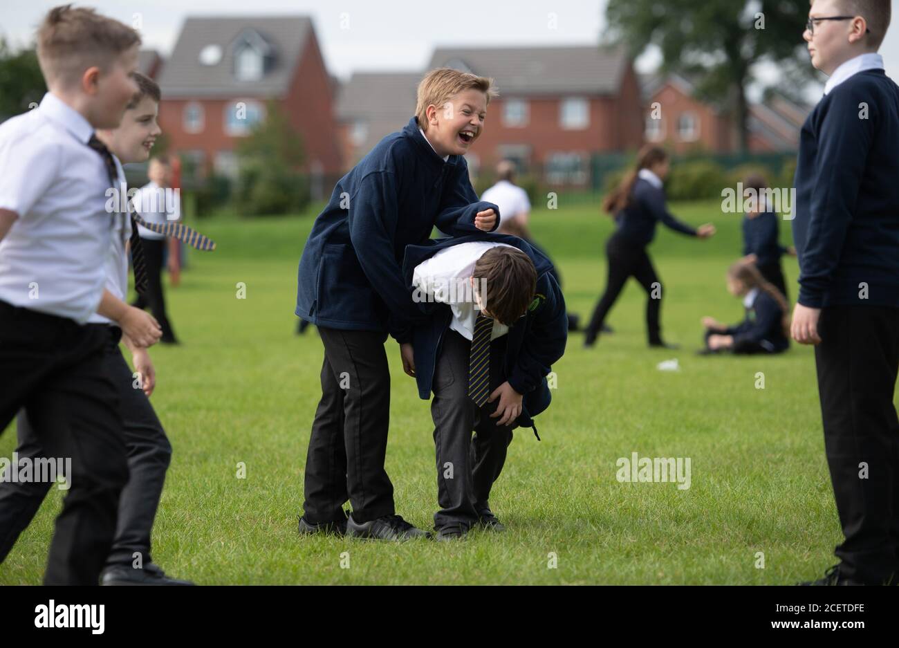 Children play on the field during play time on the first day back to school at Arbours Primary Academy in Northampton, as schools in England reopen to pupils following the coronavirus lockdown. Stock Photo