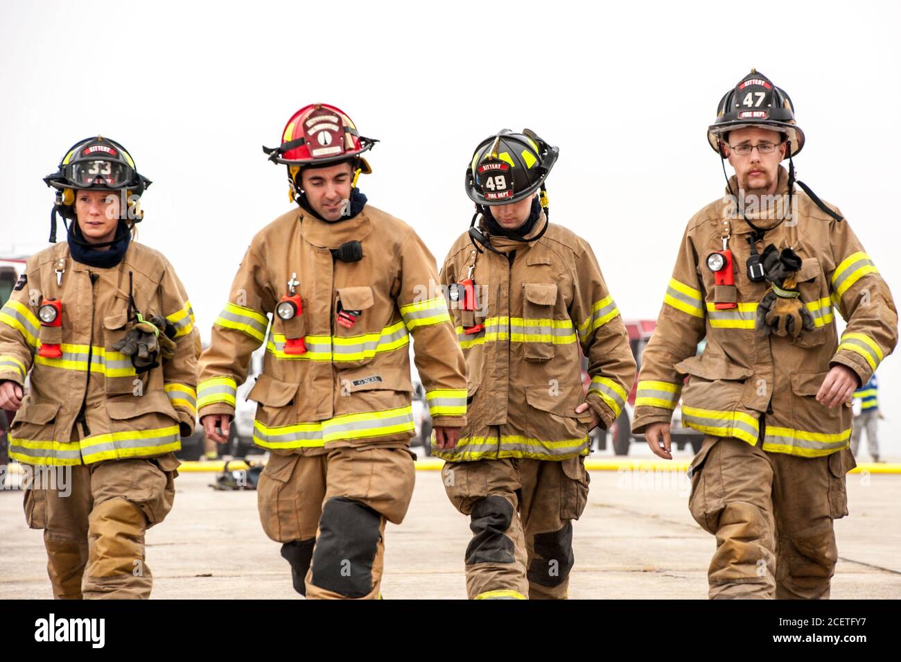 Four firefighters in uniform walking towards the camera during a full-scale emergency exercise drill at Pease International Airport in Portsmouth, NH. Stock Photo