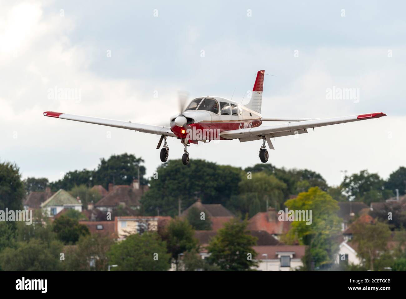 Piper PA-28R-201 Cherokee Arrow III G-BYYO light aircraft plane landing at London Southend Airport, Essex, UK, with homes on airport boundary Stock Photo