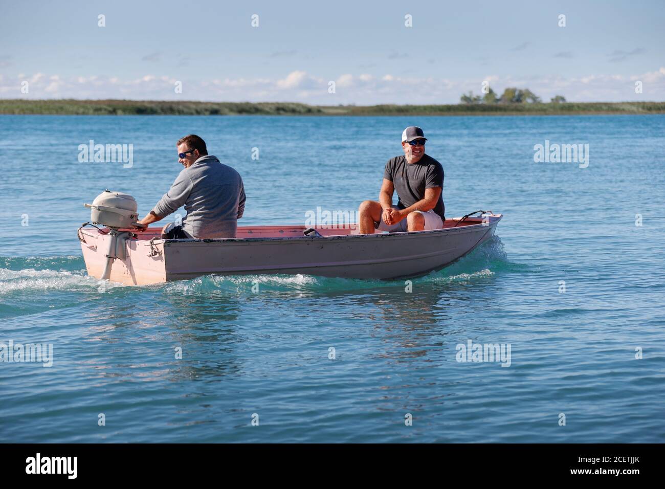 Two friends in a small fishing boat on a lake Stock Photo - Alamy