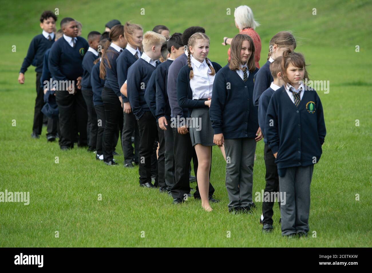 Children queue on the playing field on the first day back to school at  Arbours Primary Academy in Northampton, as schools in England reopen to  pupils following the coronavirus lockdown Stock Photo -