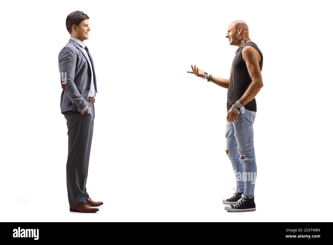 Full length profile shot of a man in a suit and a hipster guy having a conversation isolated on white background Stock Photo