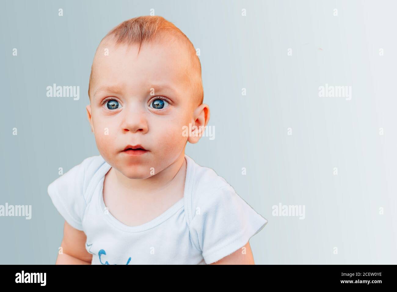 Beautiful one year old baby boy with blue eyes isolated on blue