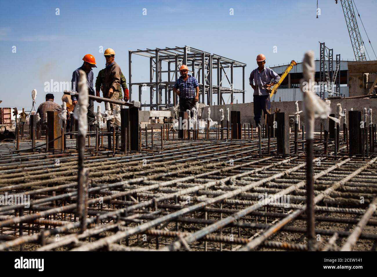 Old phosphate fertilizer plant in modernization. Workers assembling  reinforcement of new building basement. On industrial building, building structur Stock Photo