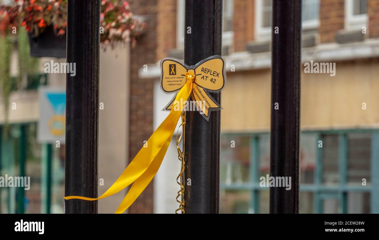 A gold ribbon is displayed in the middle of a pedestrian street to commemorate the Childhood Cancer Awareness Month. Stock Photo