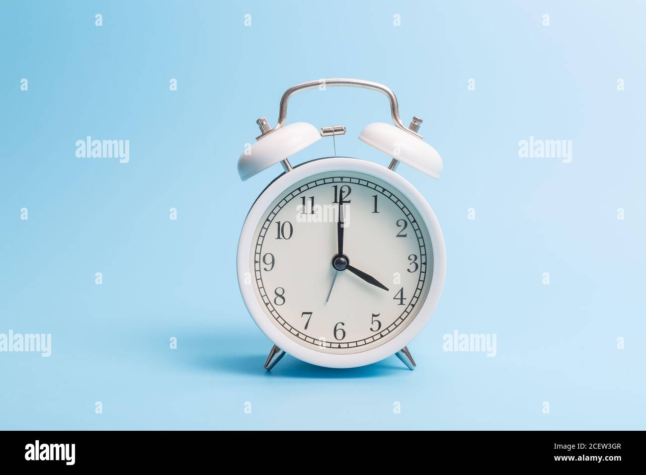 Alarm clock on blue background Stock Photo