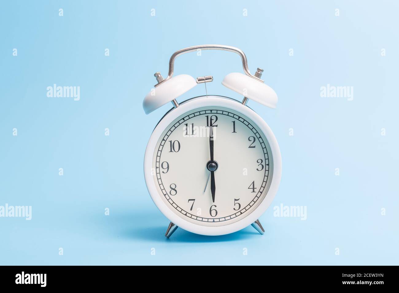 Alarm clock on blue background Stock Photo - Alamy