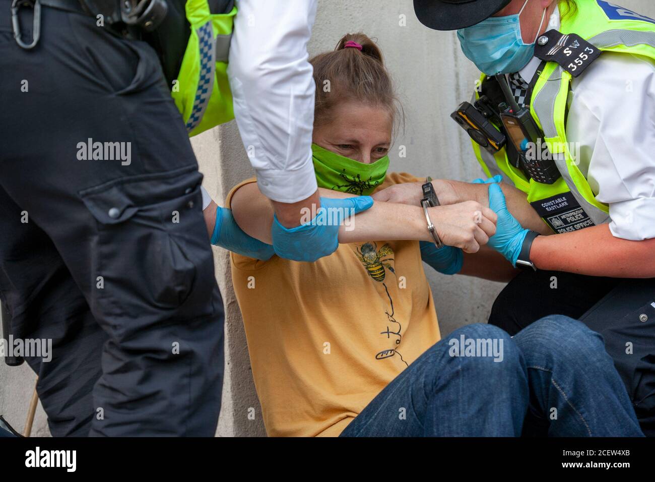 London, UK. 2nd September 2020. Extinction Rebellion protester, in handcuffs, is helped to her feet by police after being arrested, during the second day of demonstrations outside parliament. Frustrated with the government’s failure to act on the climate and ecological emergency, XR continue to protest for change. The Climate and Ecological Emergency Bill (CEE Bill), is the only concrete plan available to address this crisis, and so in their first week back in Parliament, XR demand the government Act Now and embrace this legislation. Credit: Neil Atkinson/Alamy Live News. Stock Photo