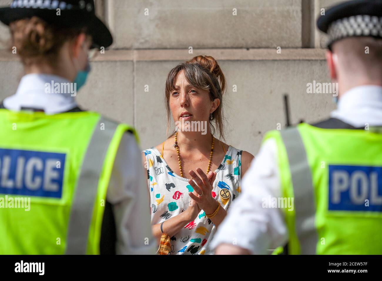 London, UK. 2nd September 2020. Extinction Rebellion protester sings and claps in front of police after being arrested, during the second day of demonstrations outside parliament. Frustrated with the government’s failure to act on the climate and ecological emergency, XR continue to protest for change. The Climate and Ecological Emergency Bill (CEE Bill), is the only concrete plan available to address this crisis, and so in their first week back in Parliament, XR demand the government Act Now and embrace this legislation. Credit: Neil Atkinson/Alamy Live News. Stock Photo
