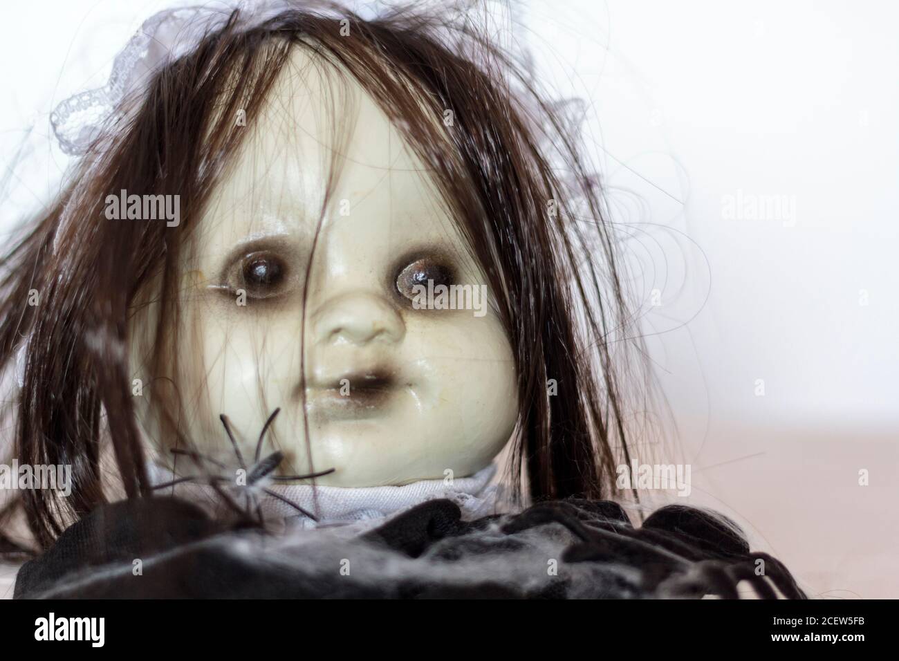 Creepy doll face with spiders. Halloween concept Stock Photo