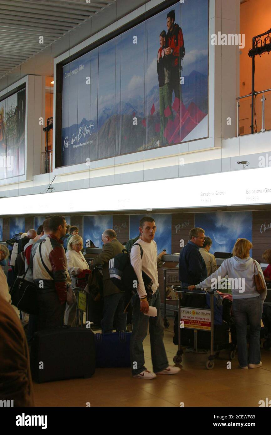 Glasgow Prestwick Airport, Ayrshire, Scotland. 19 May 2005. Passengers check in underneath the new signage and branding Stock Photo