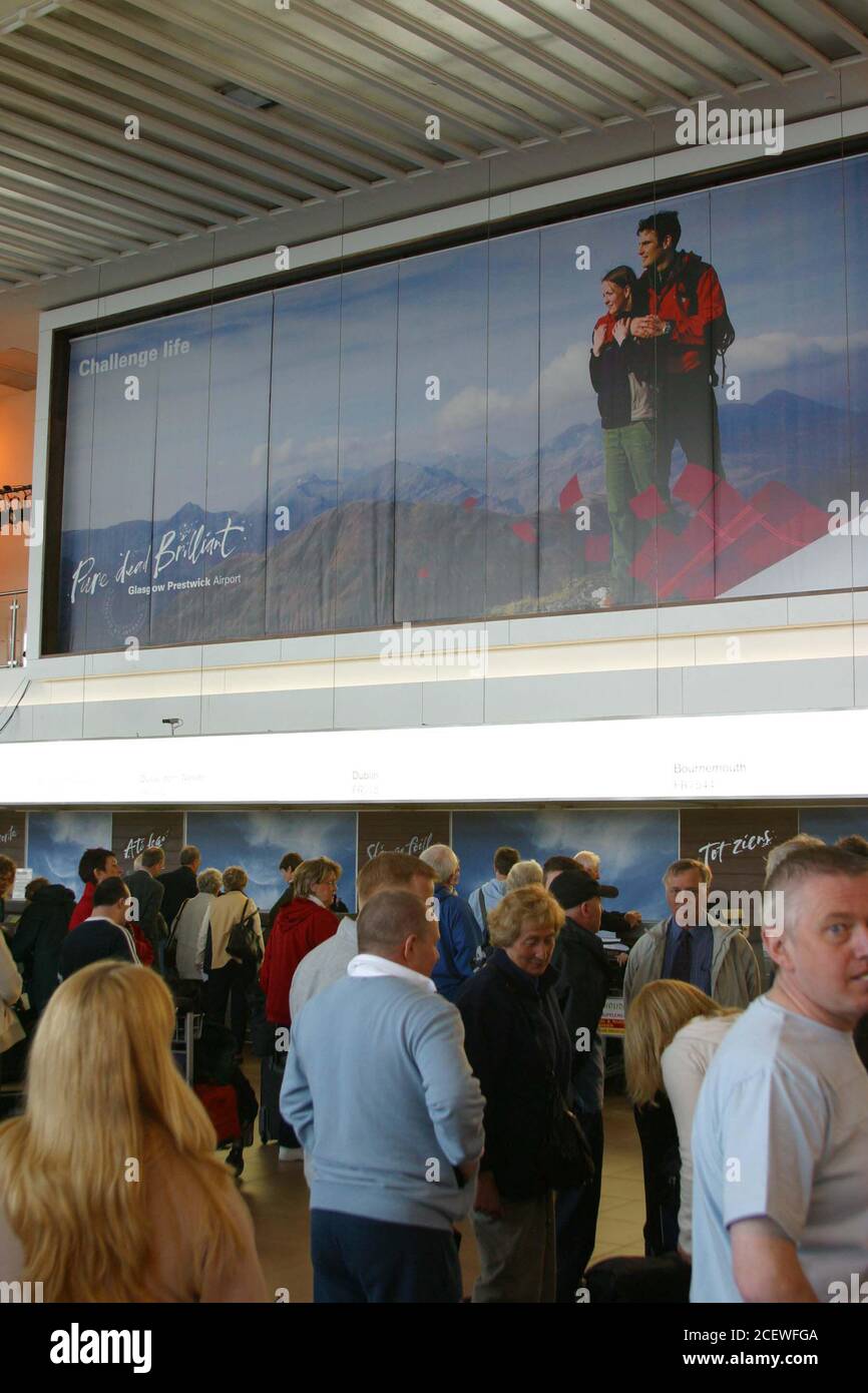 Glasgow Prestwick Airport, Ayrshire, Scotland. 19 May 2005. Passengers check in underneath the new signage and branding Stock Photo
