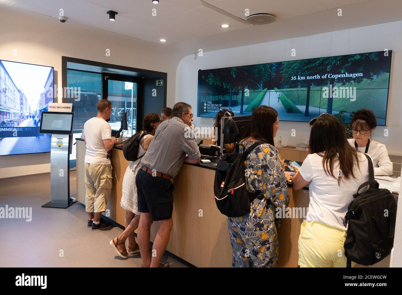 Customers talking to officials at Copenhagen Tourist Office reception Stock Photo