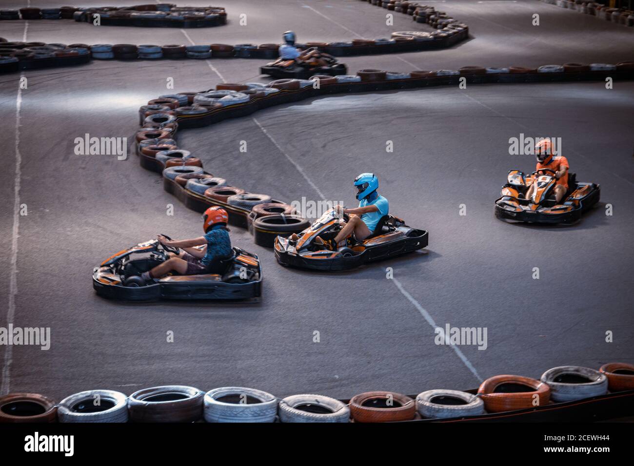 Three guys overtaking each other on an indoor karting track Stock Photo Alamy