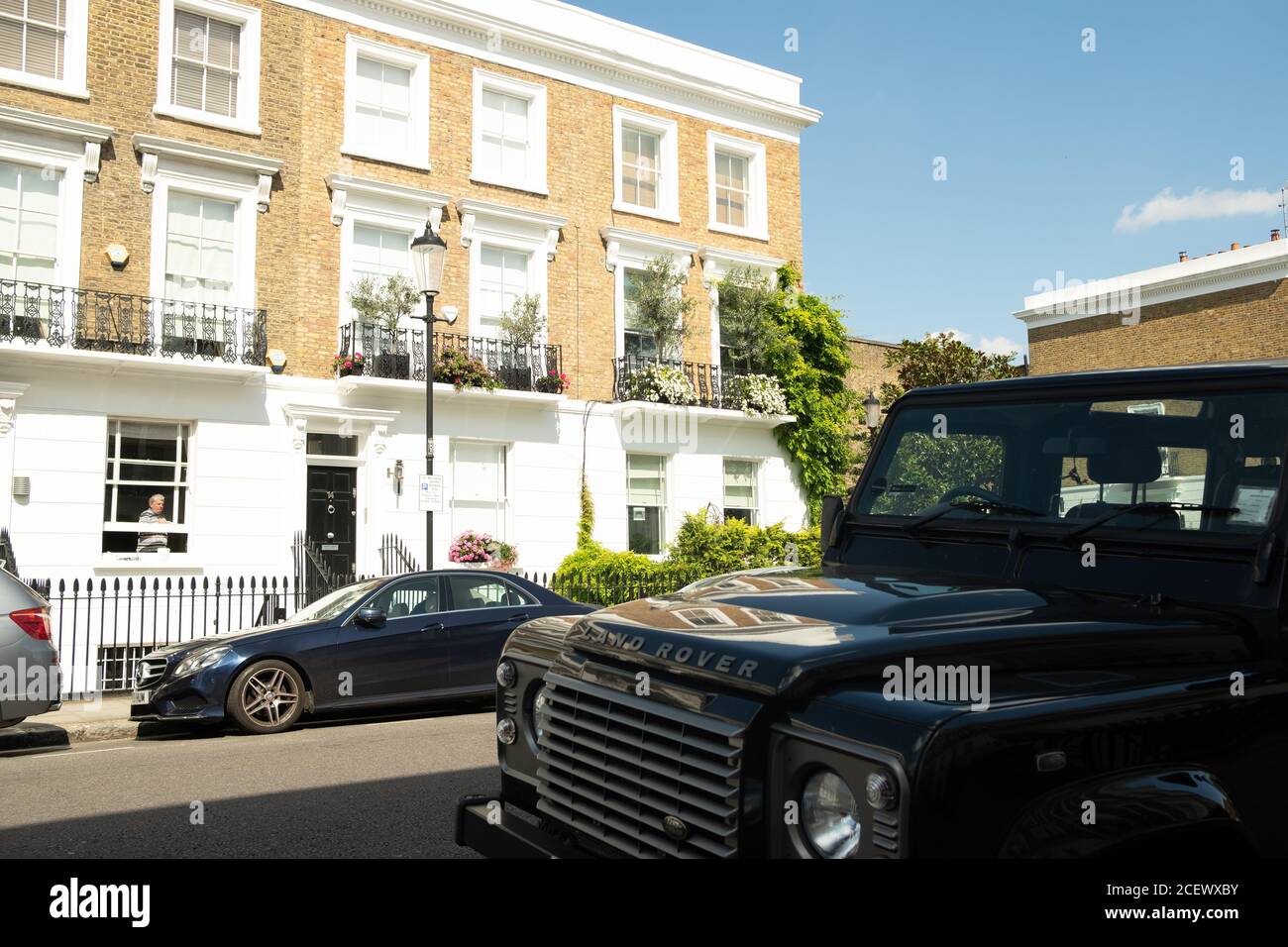 Land Rover Defender parked on typical street of beautiful white stucco terraced townhouses in Chelsea Stock Photo