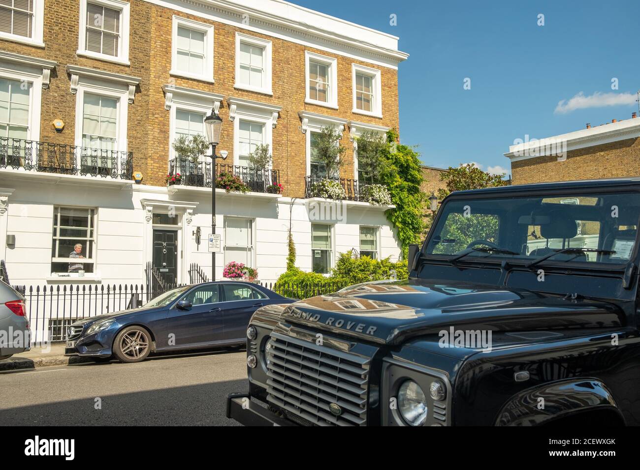 Land Rover Defender parked on typical street of beautiful white stucco terraced townhouses in Chelsea Stock Photo