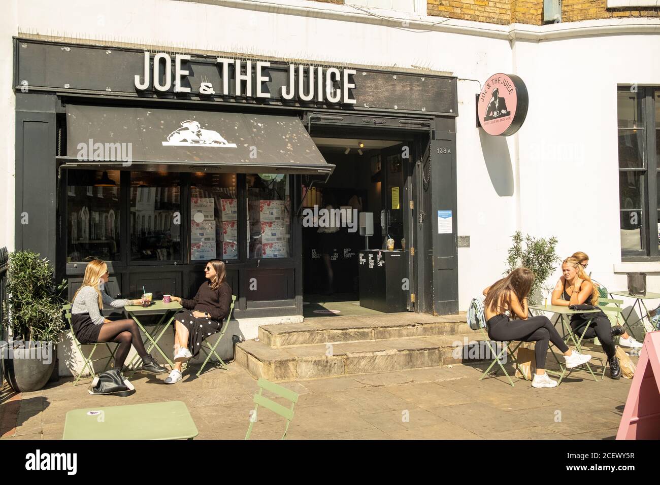 London People sitting outside at a Joe & The Juice store on the Kings