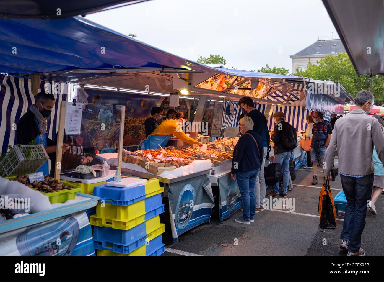 Angers, France - August 29 2020: people wearing face protective mask while shopping in the market place at France to prevent coronavirus, concept of wearing masks outdoor is mandatory, new reality, mask mode Stock Photo