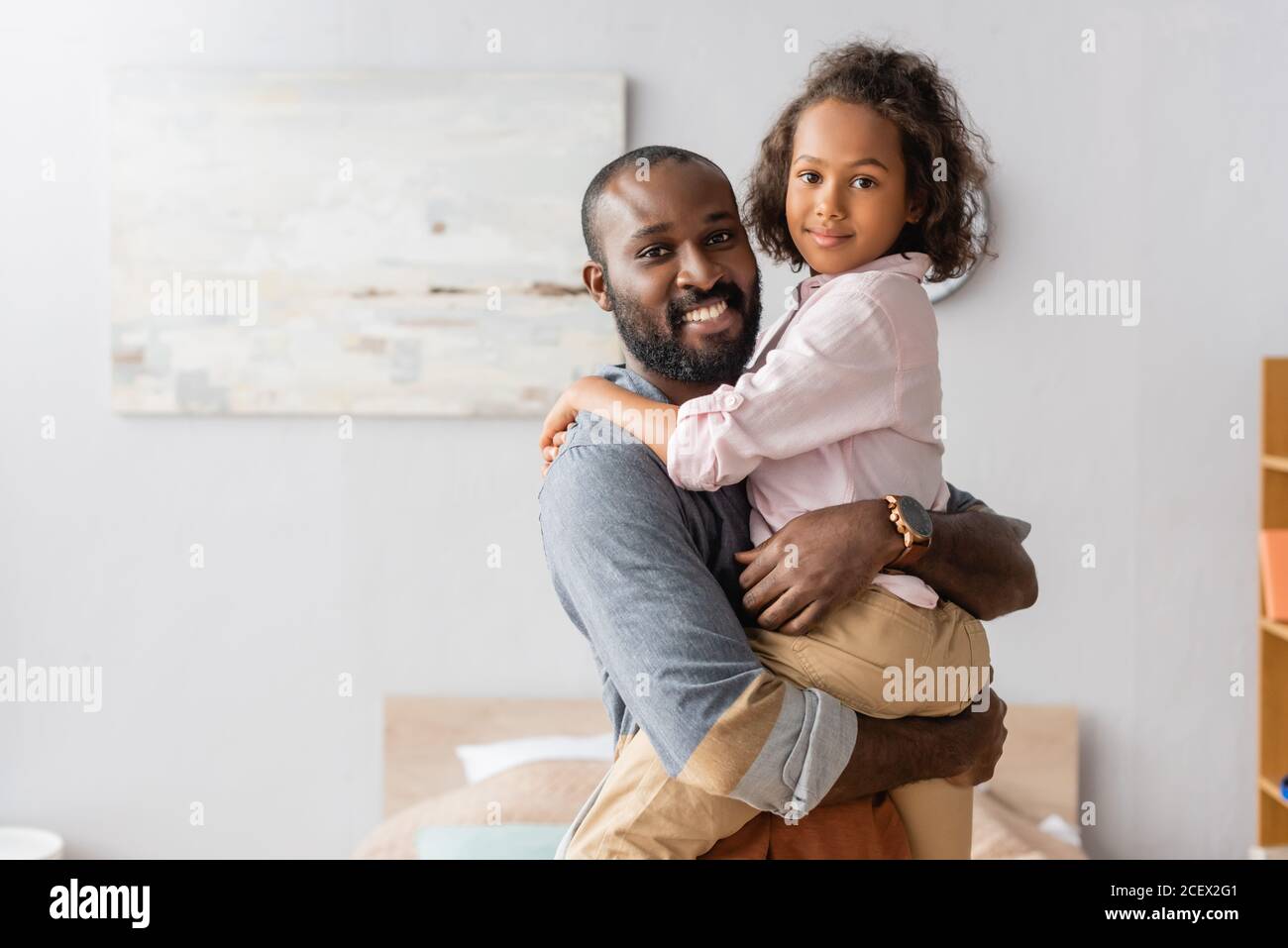 young african american father holding child on hands while looking at ...